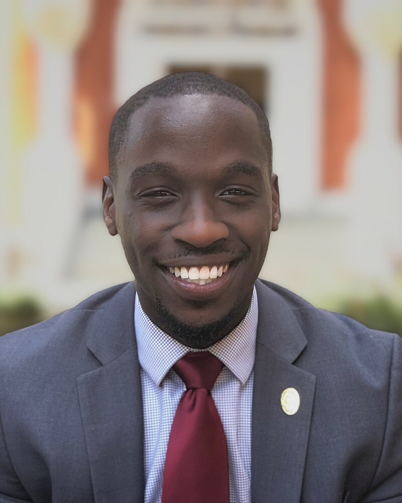 Mark Riley, Founder and CEO of Great Breads Studio, in a grey suit and burgundy tie at Morehouse College